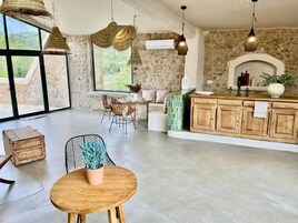 Una cocina amplia con ventanas grandes, una pared de piedra y un armario de madera.