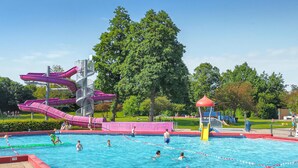 Ein Schwimmbecken mit mehreren Rutschen und einem Spielbereich.