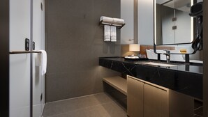 Ein modernes Badezimmer mit Marmorwaschbecken, einem Handtuchhalter, einer Bank und einem Spiegel.