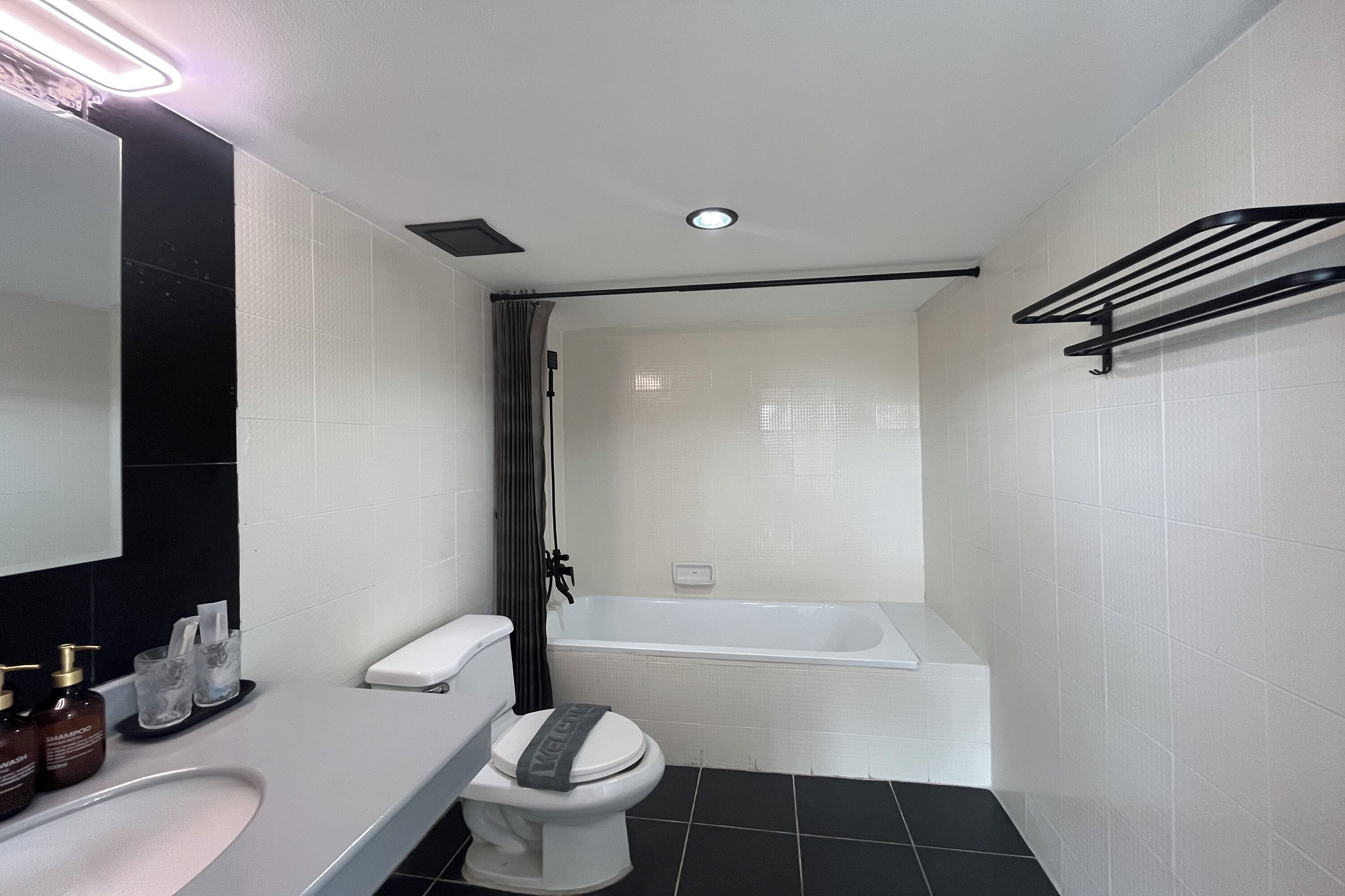 A modern bathroom with a toilet, sink, and bathtub.
