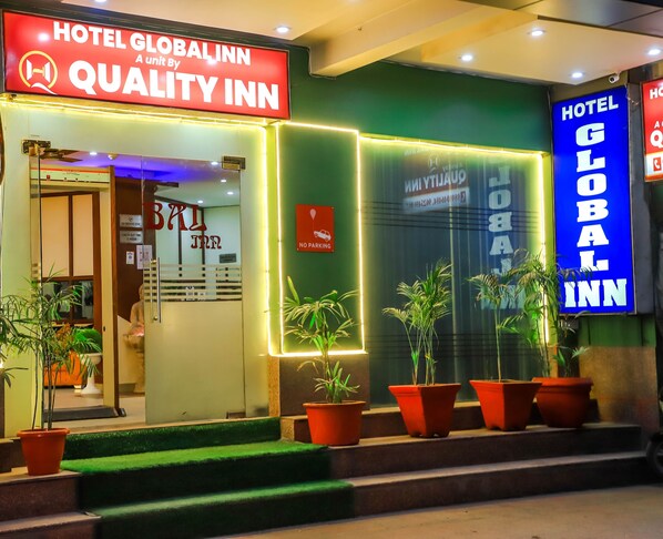 The exterior of Hotel Global Inn, featuring a prominent sign, a no parking sign, and potted plants at the entrance. - Hotel Global Inn by Quality Inn  (New Delhi)