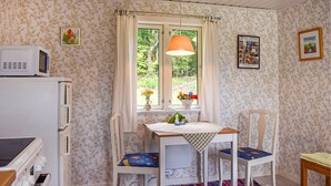 A small room with a window, a table with a checkered tablecloth, two chairs, a microwave, and a colorful rug. - 1 bedroom cozy home in Blentarp (Blentarp)