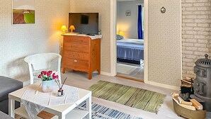 A cozy room with a TV, wooden dresser, and a bed with a blue bedspread. - 1 bedroom cozy home in Blentarp (Blentarp)