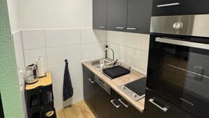 A compact kitchen with black cabinets, a stainless steel oven, and a small countertop.
