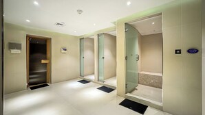 Een moderne badkamer met een douchecabine van glas, een toilet en een wastafel.