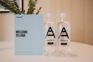 Un cartel de bienvenida y dos botellas de agua marca 'andea' con un logotipo, sobre una mesa.