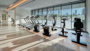 A modern gym with treadmills, elliptical machines, and weight stations. - Downtown Views (Dubai)