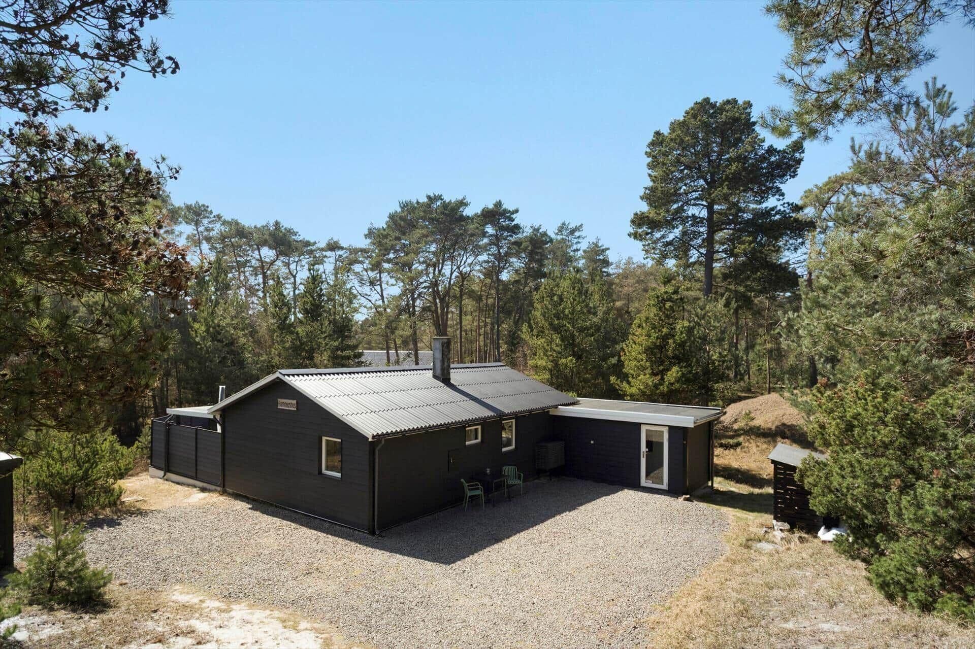 Une cabane à deux étages avec une allée en gravier et un petit espace patio.