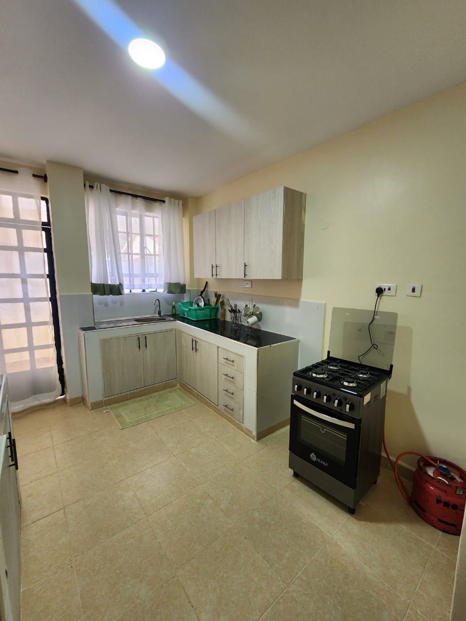Una cocina con estufa a gas, horno y alacenas.