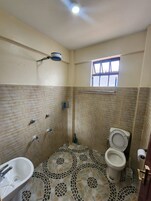 Un baño con ducha, inodoro y lavabo.