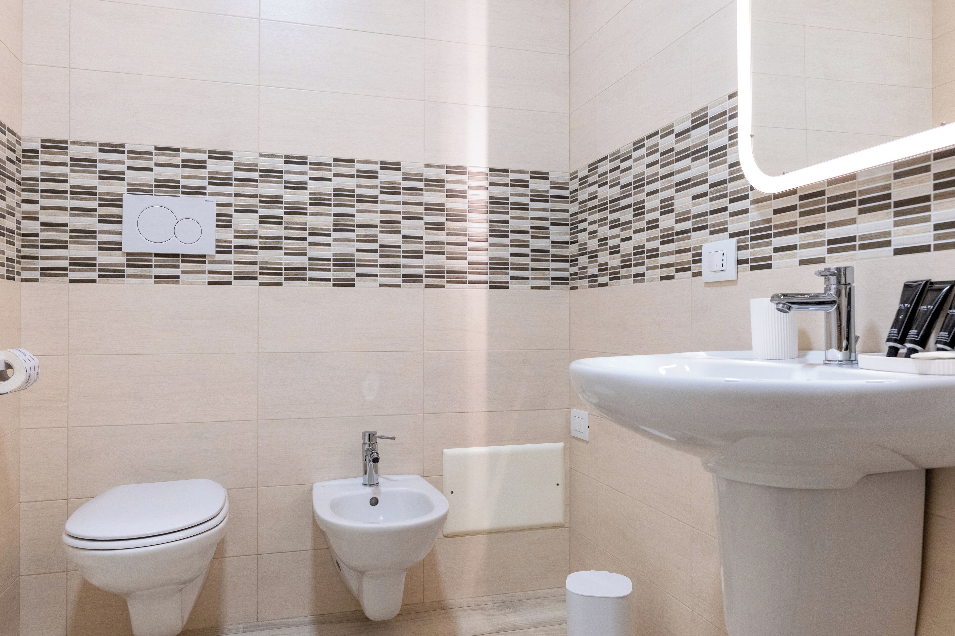 Un baño moderno con inodoro, bidé y lavamanos.