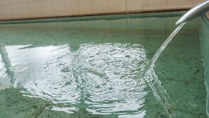 Una piscina con agua cristalina y un grifo visible.