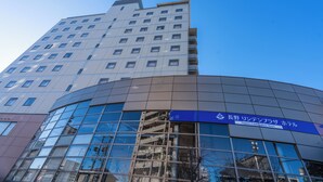 Un moderno edificio de hotel con fachada de vidrio curva y un cartel que indica que es el Hotel Nagano Lindenschloß Plaza.