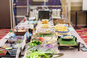 Una mesa de bufé con diferentes alimentos y utensilios.