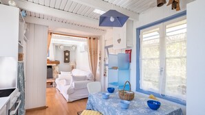 Ein Zimmer mit einem Bett, einem Tisch mit Schalen, einem Korb und einem Fenster mit Blick.
