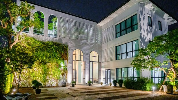 A modern building with arched windows and a covered walkway. - O2 The Residence (Kanchanaburi)