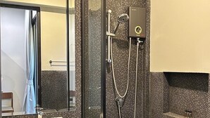 A modern bathroom with a glass-enclosed shower, a white sink, and a large mirror. - O2 The Residence (Kanchanaburi)