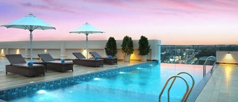 Una piscina al aire libre, sombrillas