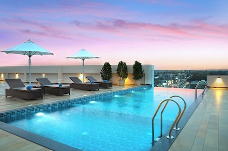 Una piscina al aire libre, sombrillas