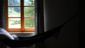 A room with a window, a hammock, and a bed. - Peaceful Alpine Hideaway | Between Mountains & Streams (Bad Gastein)