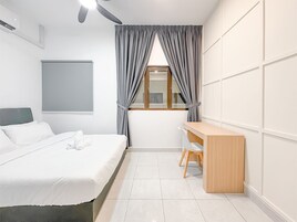 Un dormitorio moderno con cama, escritorio y ventana con cortinas.