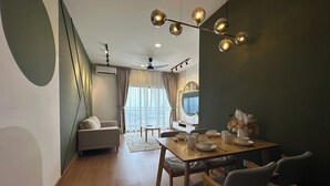 Una sala de estar moderna con comedor, que incluye una mesa de madera, sillas, un sofá y un ventilador de techo.