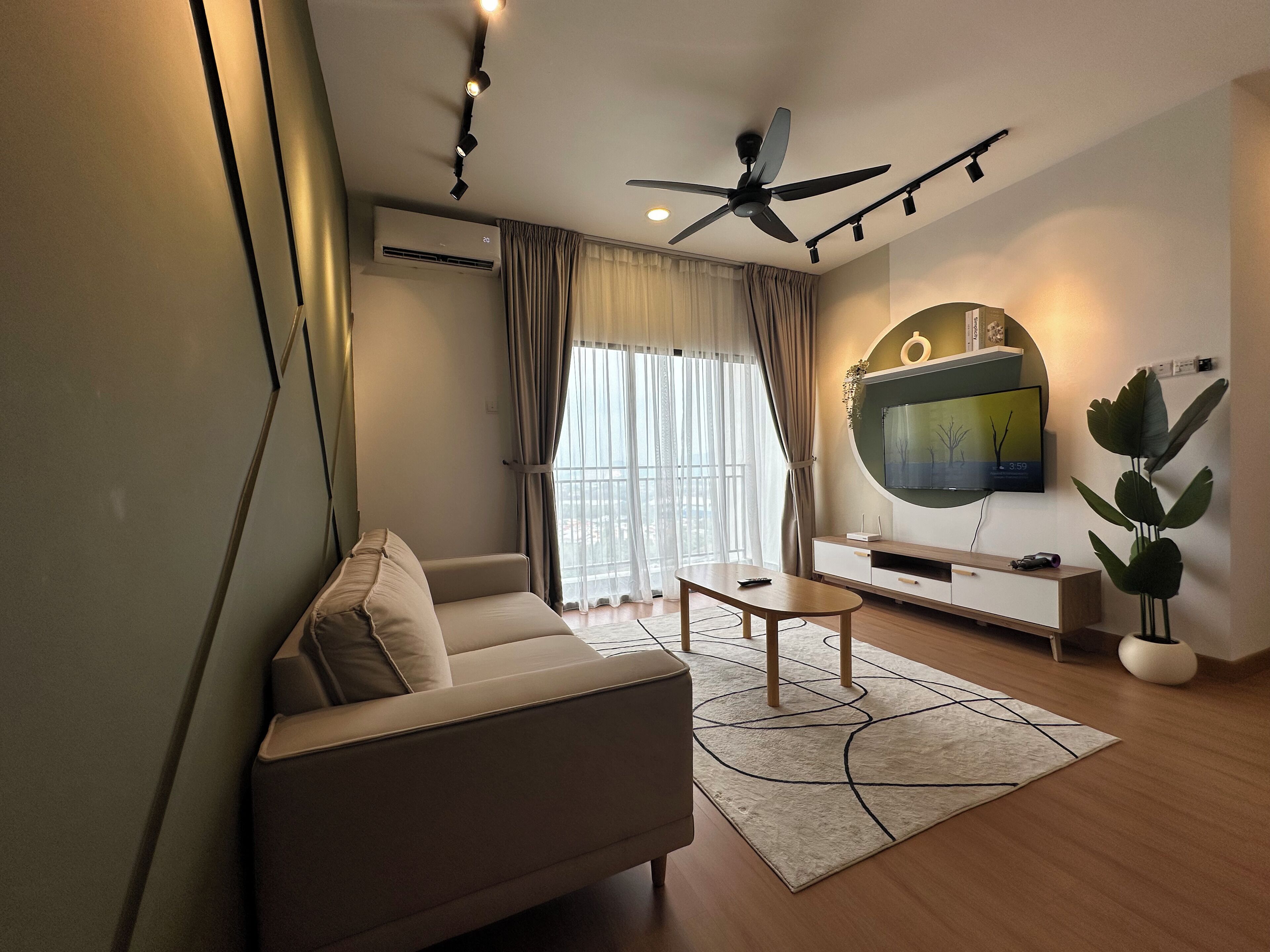 A modern living room with a sofa, coffee table, and a flat-screen TV mounted on the wall.