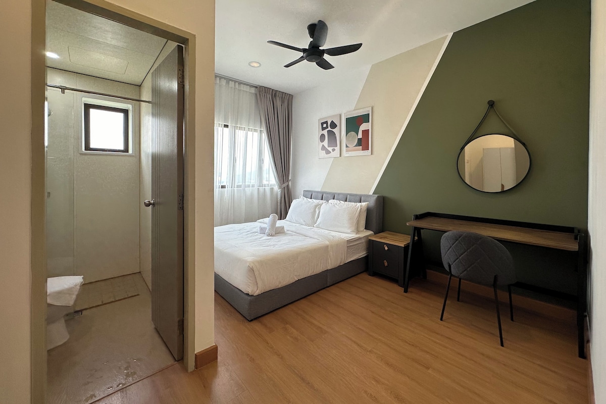A bedroom with a bed, a desk, a chair, a ceiling fan, and a window with curtains.