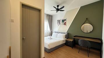 Une chambre à coucher comprenant un lit, un bureau, une chaise, un ventilateur de plafond et un miroir fixé au mur.