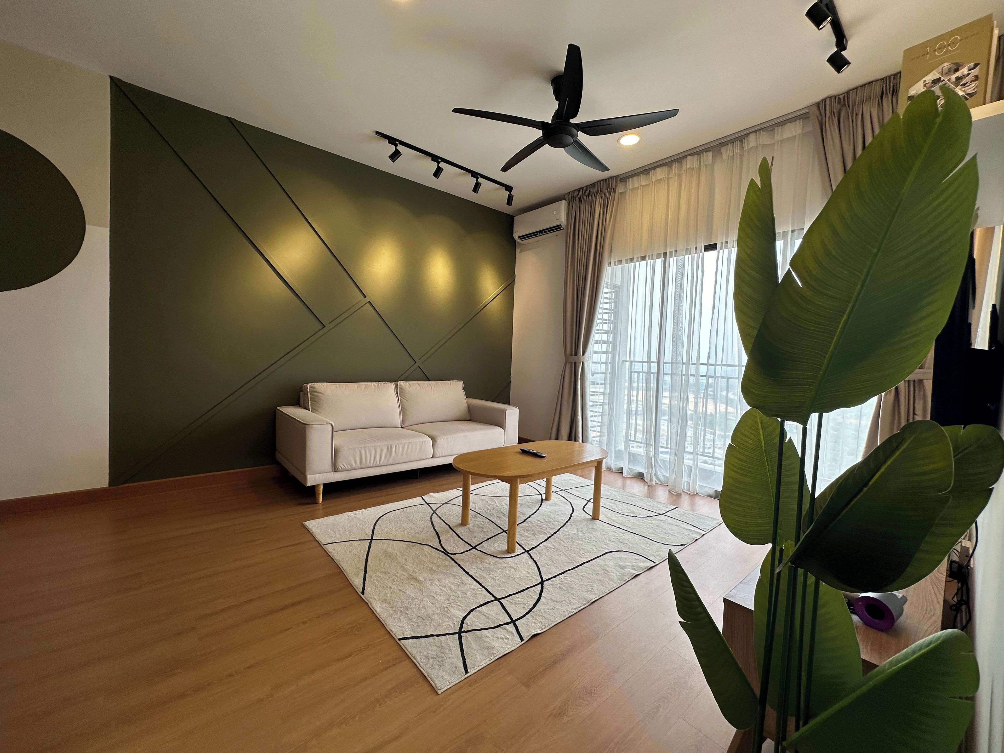 Uma sala de estar moderna com sofá, mesa de centro e janelas amplas.