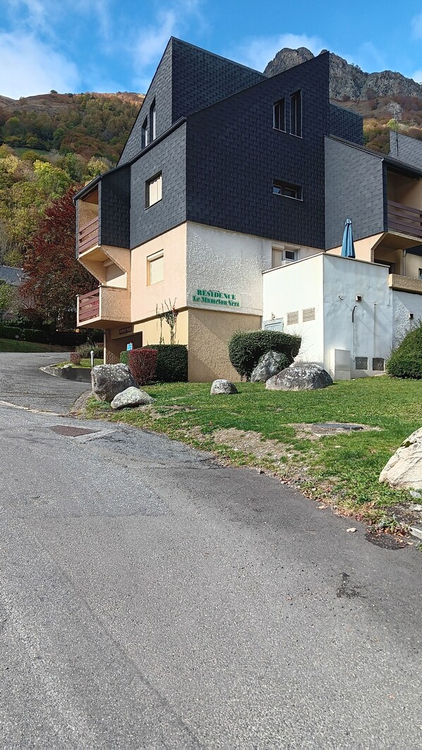 Ein modernes, zweistöckiges Gebäude mit dunklem Dach und beige farbenen Wänden, mit der Aufschrift „RESIDENCE 16 WILSON VER.“