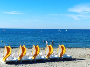 A beach with several yellow and white sun loungers lined up on the sand. - 2-room apartment with enclosed loggia, canal view, garage and WIFI (Sète)