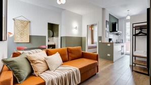Una sala de estar moderna con sofá, comedor y cocina.