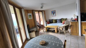 Een knus ingerichte kamer met een bed, een eettafel en een keukenhoek.