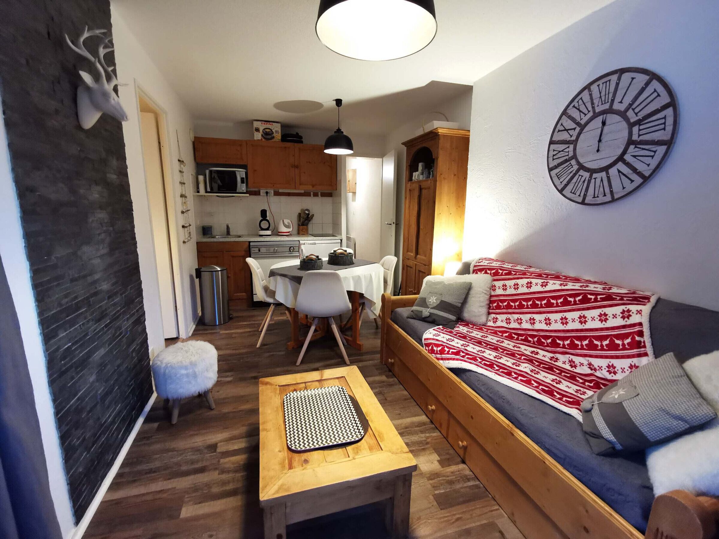 A cozy living room with a sofa, a wooden coffee table, and a dining area with a table and chairs.