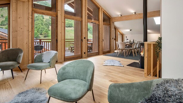 A spacious room with wooden beams, large sliding glass doors, and a fireplace. - Duplex at the slopes with sauna, 5 bedrooms for 12 (Saint-Martin-de-Belleville)