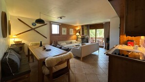 Un salon chaleureux avec une cheminée, un coin repas et une cuisine dotée de meubles en bois.