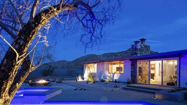 A modern house with a swimming pool at dusk.
