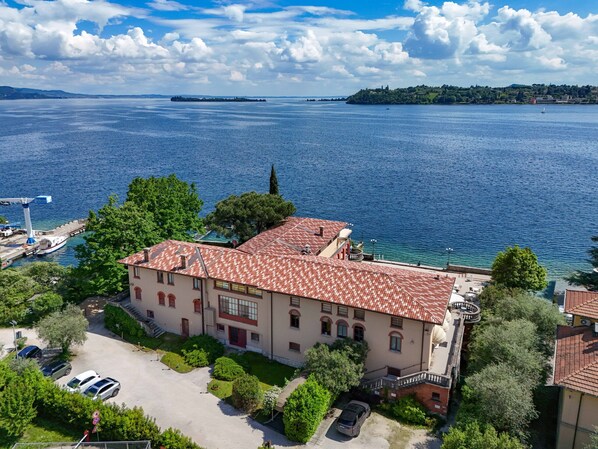 A building with a red-tiled roof, a courtyard, and a view of a large body of water.