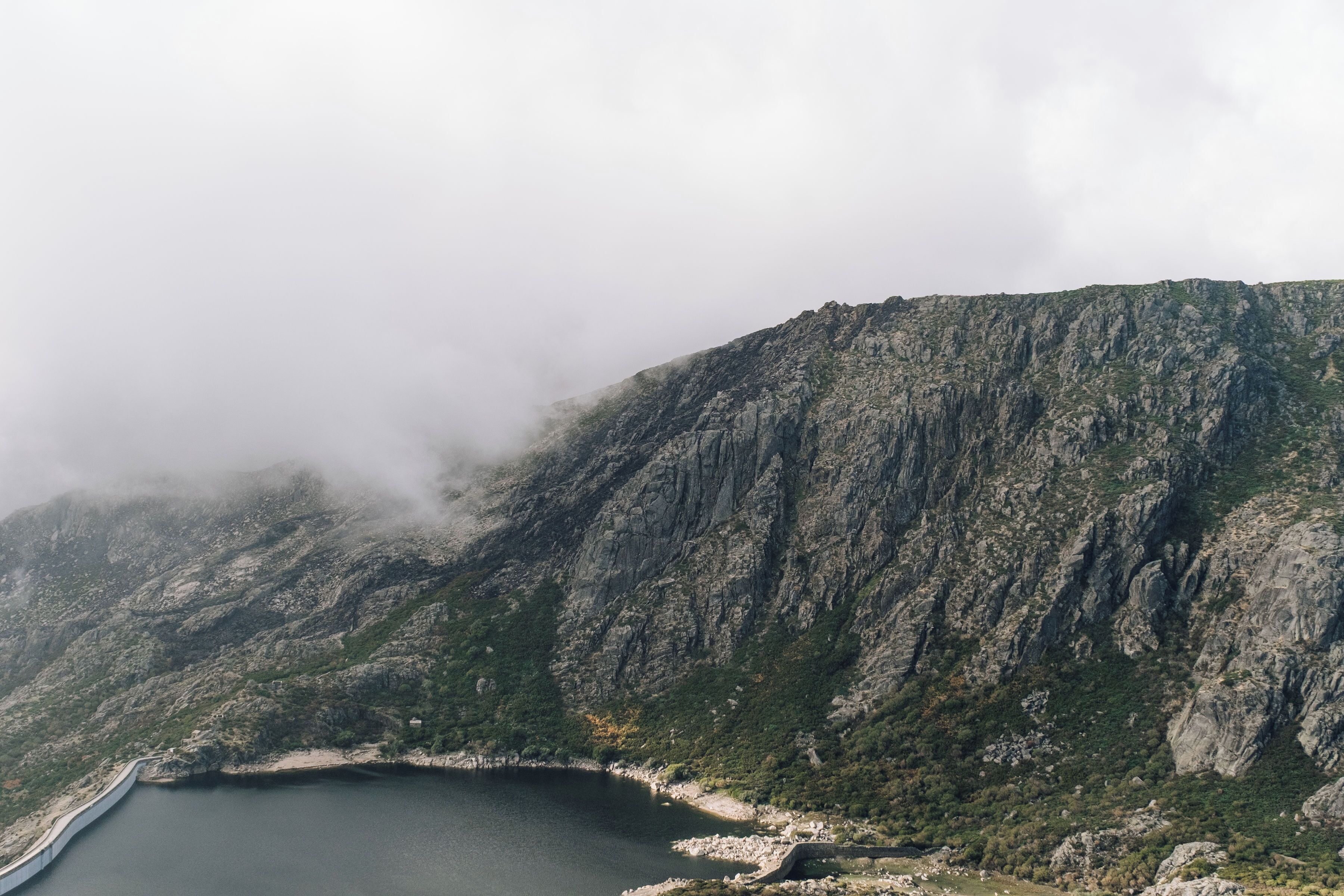 A mountainous landscape with a lake and a winding road.