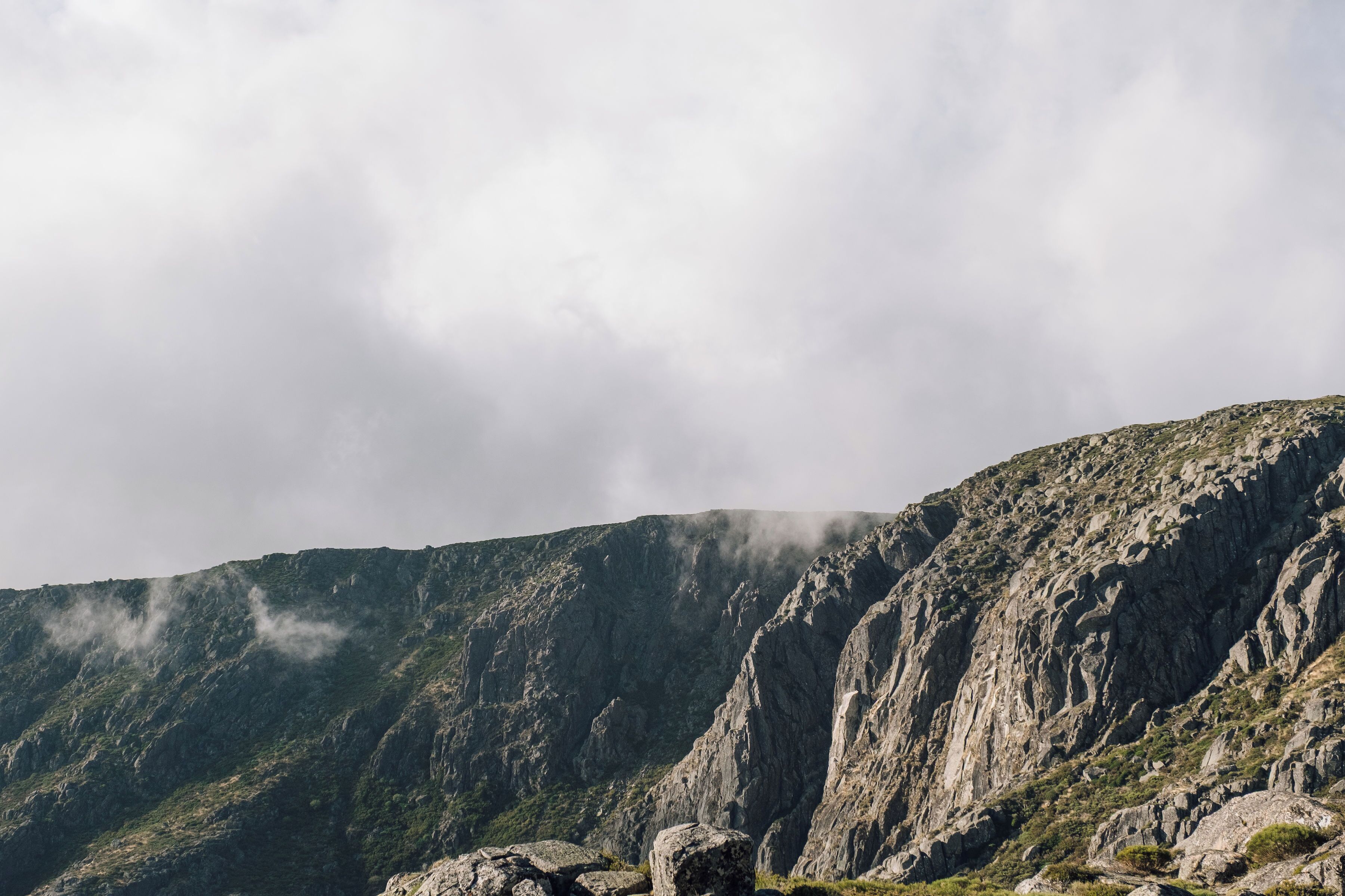 A mountainous landscape with rocky terrain and sparse vegetation.