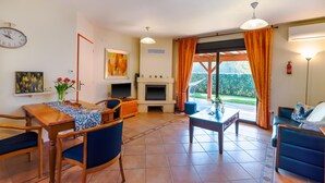 Una sala de estar con chimenea, comedor y vistas al exterior.