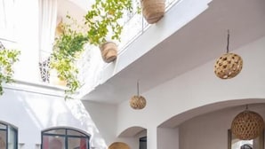 Un pati amb piscina, zones d'estar i plantes penjants.