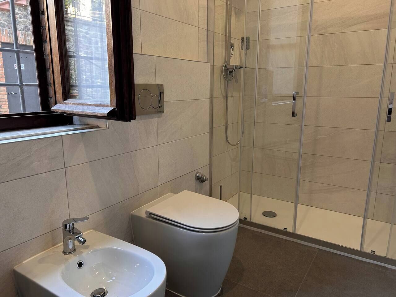 A bathroom with a toilet, sink, and glass-enclosed shower.