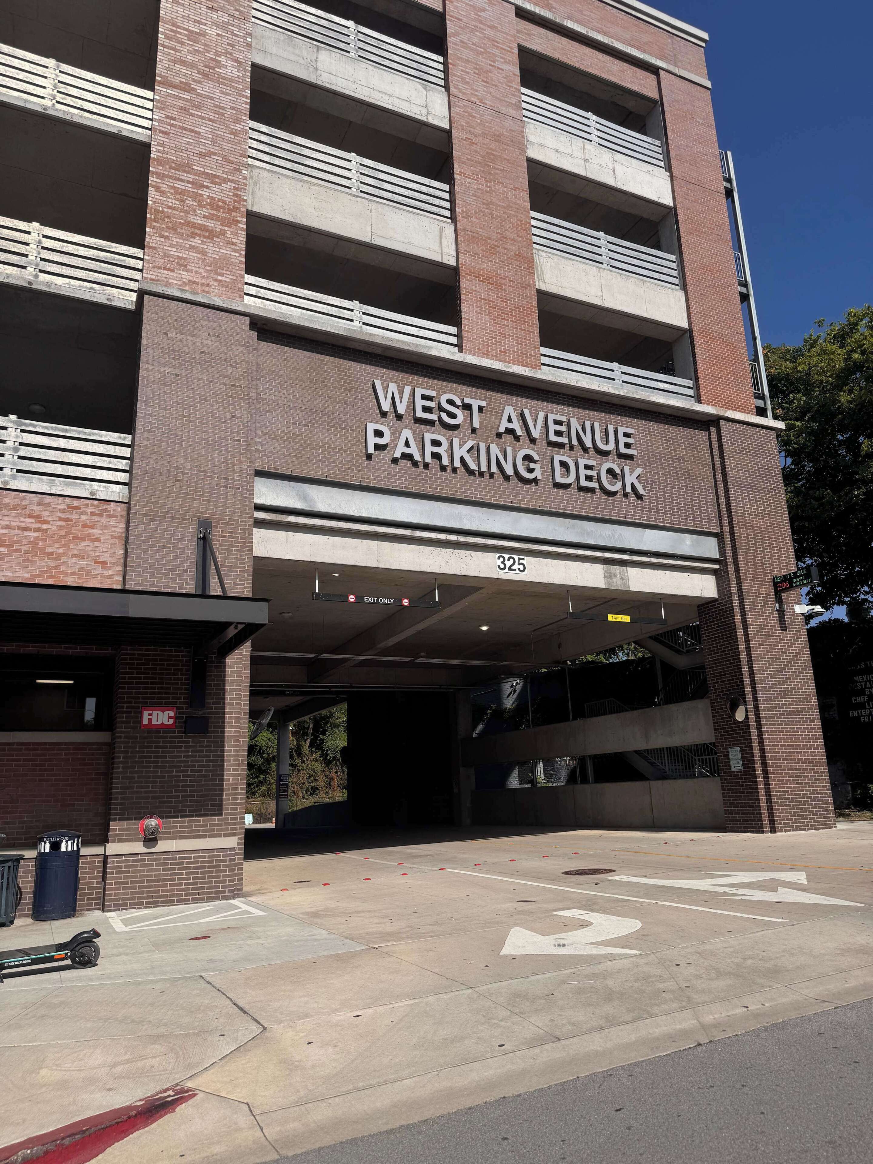 Parcheggio multipiano con un cartello che indica 'WEST AVENUE PARKING DECK'.