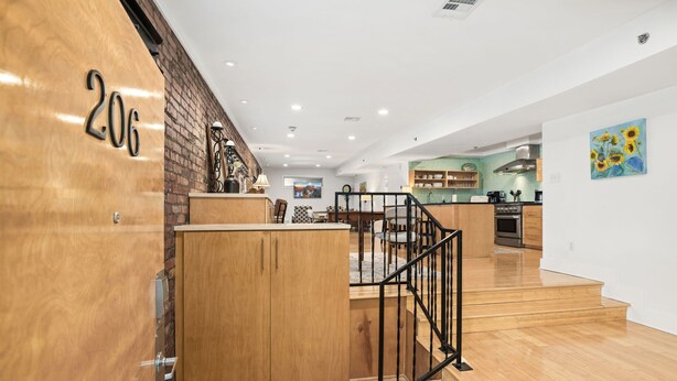 Un interior moderno con escalera de madera, zona de cocina y comedor.