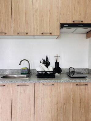 Kylskåp, mikrovågsugn, spishäll och grytor/köksredskap