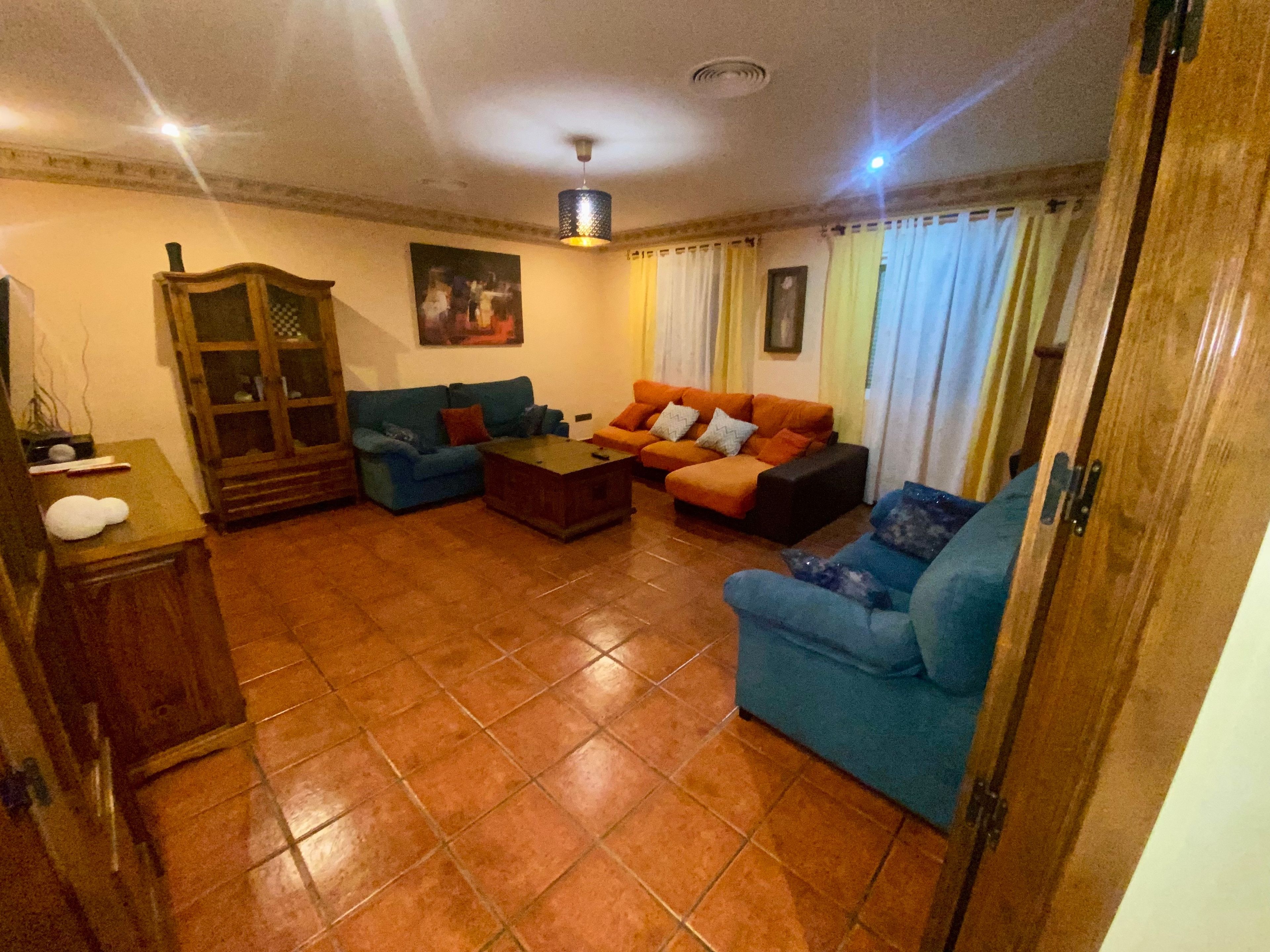 A living room with a sofa set, a coffee table, and a cabinet.