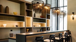 Una cocina moderna con una isla central, taburetes de bar e iluminación colgante.