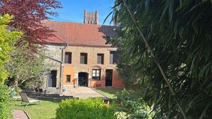 A brick building with a red-tiled roof, a visible chimney, and a front door. - Imperial Suite & Spa (Béthune)